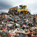 A dozer on top of a pile of surplus sent to landfill