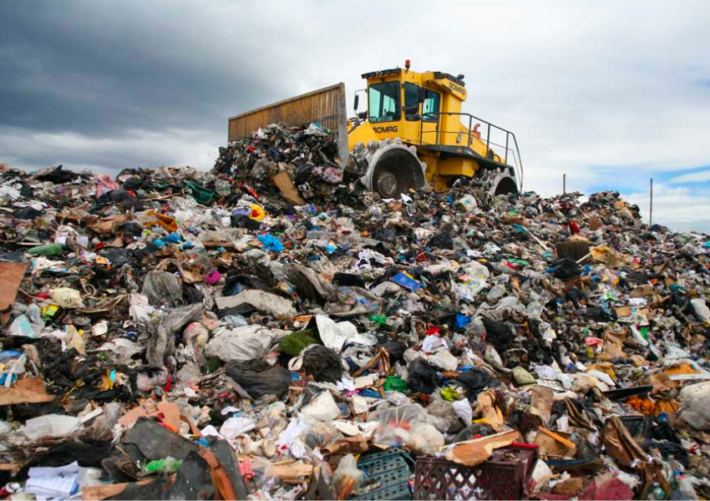 A dozer on top of a pile of surplus sent to landfill